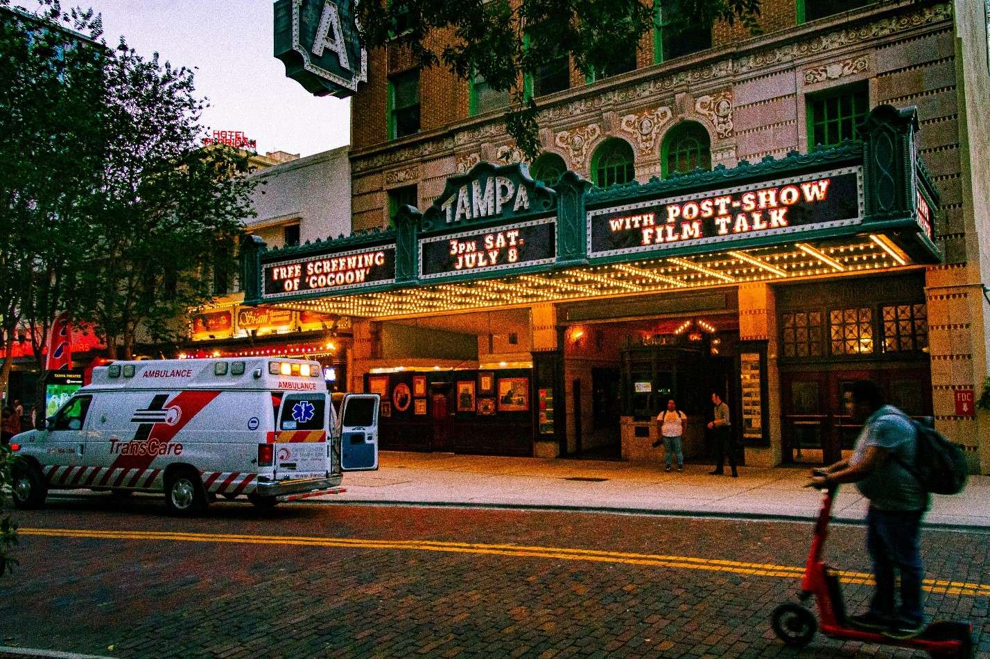 A Bustling Street Scene in Tampa at Dusk, Featuring the Historic Tampa Theatre