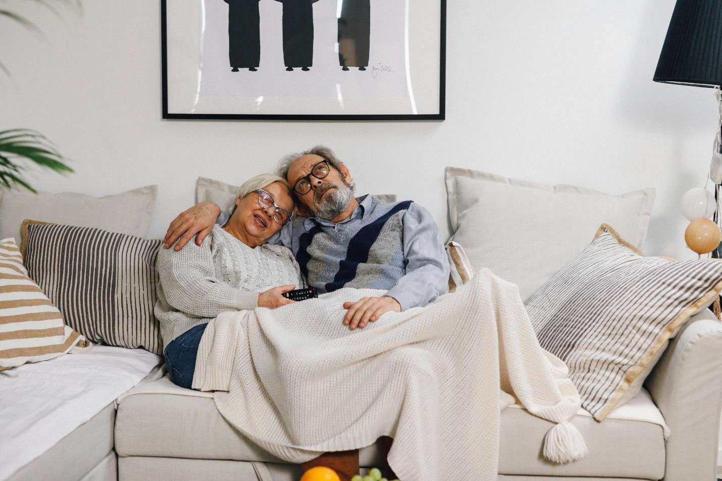 An Elderly Couple Comfortably Snuggling on a Couch