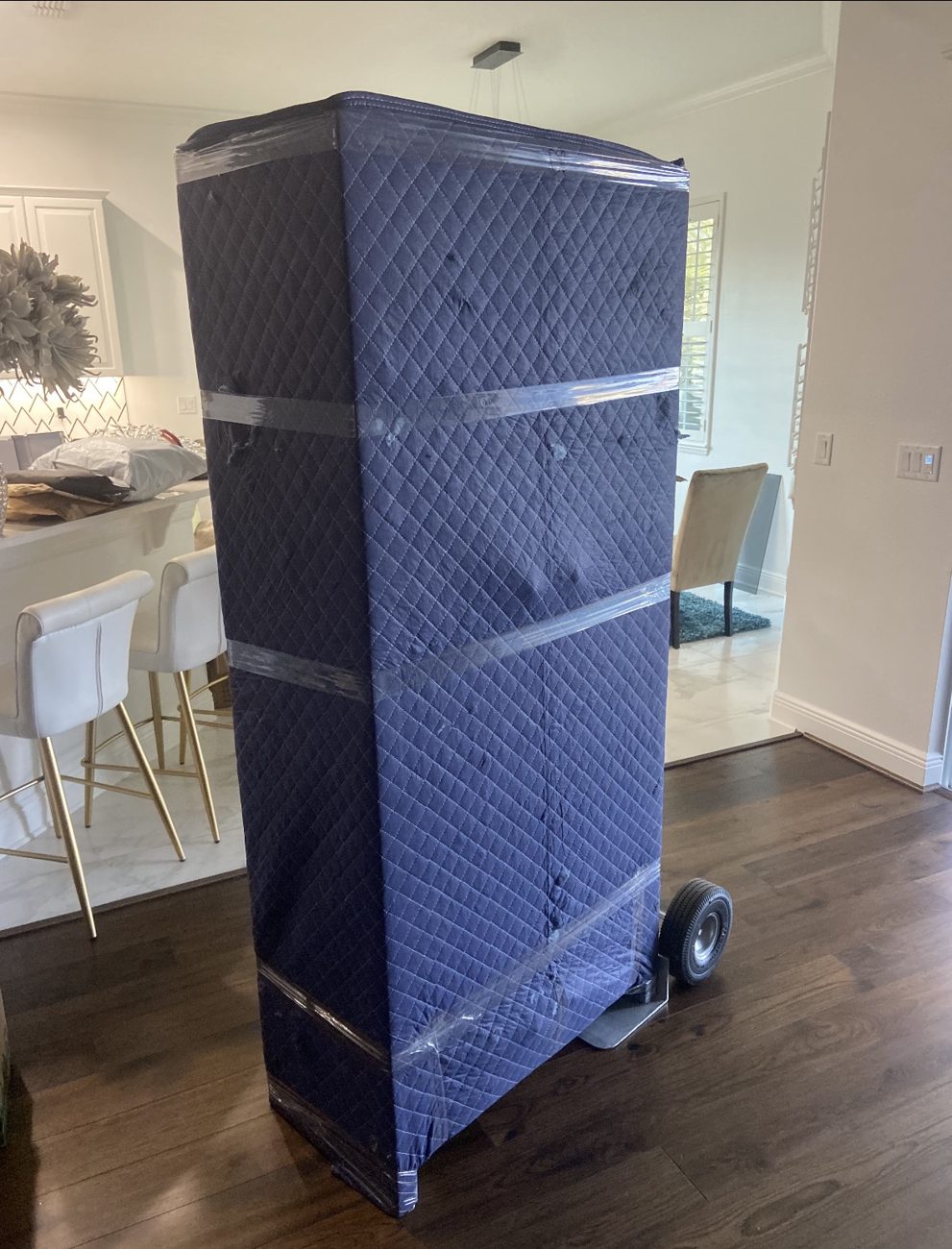 Furniture fully padded and secured on a dolly mid-move